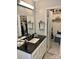 Bathroom with black countertop, vanity with drawers and doors, and a mirror with decorative shelving at 7412 Broken Oak Ln, Charlotte, NC 28226