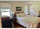 Cozy bedroom features a queen bed with patterned white bedding, a window for natural light and a nightstand at 7412 Broken Oak Ln, Charlotte, NC 28226
