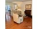 Bright living room features hardwood floors, a comfortable sofa, side tables, and natural light at 7412 Broken Oak Ln, Charlotte, NC 28226