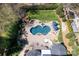 Stunning aerial view of a backyard oasis with a custom-designed pool, spa, and meticulously landscaped surroundings at 880 Craigmont Nw Ln, Concord, NC 28027