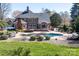 Lush backyard featuring a pool, patio, and mature trees provides an excellent outdoor retreat at 880 Craigmont Nw Ln, Concord, NC 28027