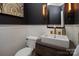 Powder room features modern vanity with gold accents, decorative lighting, and wainscoting at 880 Craigmont Nw Ln, Concord, NC 28027