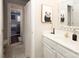 Bright bathroom with a white vanity, a gold faucet and a view into the living room at 880 Craigmont Nw Ln, Concord, NC 28027