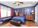 Comfortable bedroom with blue walls, tray ceiling, and hardwood floors bathed in natural light at 9200 Surrey Rd, Mint Hill, NC 28227