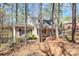 Charming brick house nestled amongst the trees and a black iron fence surrounding the yard at 9200 Surrey Rd, Mint Hill, NC 28227