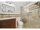 Updated bathroom with a glass-enclosed shower, elegant vanity, and stone tiling at 9209 Tibble Creek Way, Charlotte, NC 28227