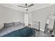 A cozy bedroom featuring a ceiling fan, sleek gray walls, and modern gray-toned furniture at 9209 Tibble Creek Way, Charlotte, NC 28227
