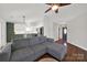 Bright and spacious living room with a gray sectional couch, hardwood floors, and a view into the kitchen at 9209 Tibble Creek Way, Charlotte, NC 28227