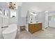 Bright bathroom featuring a soaking tub, wooden vanity, and modern fixtures at 110 Sonnys Way, Fort Mill, SC 29708