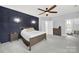 Modern bedroom with a dark blue accent wall, sconces, and a ceiling fan at 110 Sonnys Way, Fort Mill, SC 29708