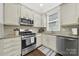 This charming kitchen features light-colored cabinets, granite countertops, and stainless steel appliances at 110 Sonnys Way, Fort Mill, SC 29708