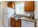 A well-lit kitchen features white appliances, granite countertops, and wood cabinets at 1101 E Morehead St # 31, Charlotte, NC 28204