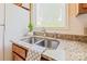 Bright kitchen sink with granite countertops, oak cabinets, and stainless steel fixtures at 1101 E Morehead St # 31, Charlotte, NC 28204