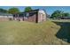 Back exterior featuring a brick facade, small windows and a lush, green yard at 1108 Pearson Dr, Rock Hill, SC 29730