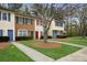 Exterior view of townhomes with manicured lawns, colorful doors and shutters, and mature trees at 1113 Keswick Pl # 118, Monroe, NC 28112