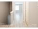 An empty hallway features light gray walls, gray tone laminate flooring, and bright white doors and trim at 1113 Keswick Pl # 118, Monroe, NC 28112