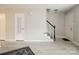 A open floor plan living room with light grey walls, gray tone laminate flooring, and a white entry door at 1113 Keswick Pl # 118, Monroe, NC 28112