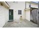Back patio with a green door and partial fence view, providing an intimate outdoor living space at 1113 Keswick Pl # 118, Monroe, NC 28112