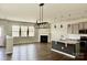 Bright open concept living room and kitchen area with a fireplace, island seating and lots of natural light at 11220 Westbranch Pkwy, Davidson, NC 28036