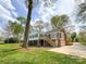 Expansive backyard with mature trees, deck, a ground-level patio, and garage access at 12011 Stoney Meadow Dr, Mint Hill, NC 28227
