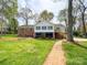 Expansive backyard with a brick walkway leading to a lush green lawn and mature trees at 12011 Stoney Meadow Dr, Mint Hill, NC 28227
