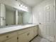 Spacious bathroom with large mirror, vanity with drawers, and a glass door shower with tile surround at 12011 Stoney Meadow Dr, Mint Hill, NC 28227