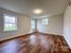 Bedroom featuring wood flooring and two windows that let in natural light to brighten the space at 12011 Stoney Meadow Dr, Mint Hill, NC 28227