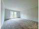A bright bedroom with plush carpet and a large window overlooking the yard at 12011 Stoney Meadow Dr, Mint Hill, NC 28227