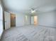 Spacious bedroom with neutral carpet and a ceiling fan, offers multiple doorways and natural light at 12011 Stoney Meadow Dr, Mint Hill, NC 28227