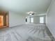 An expansive bedroom with neutral carpet, a ceiling fan, and large, bright windows at 12011 Stoney Meadow Dr, Mint Hill, NC 28227