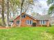 Charming brick home featuring a manicured lawn and complemented by vibrant blue shutters at 12011 Stoney Meadow Dr, Mint Hill, NC 28227