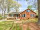 Traditional brick home with a welcoming front porch and eye-catching blue shutters at 12011 Stoney Meadow Dr, Mint Hill, NC 28227