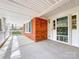 Covered front porch showcasing brick accents and a storm door entry at 12011 Stoney Meadow Dr, Mint Hill, NC 28227