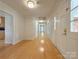 Bright hallway with pristine hardwood floors, white walls, and multiple doorways at 12011 Stoney Meadow Dr, Mint Hill, NC 28227