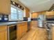 Well-lit kitchen featuring stainless steel appliances, wood cabinets, and decorative tile backsplash at 12011 Stoney Meadow Dr, Mint Hill, NC 28227