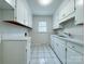 Bright laundry room featuring tile flooring, white cabinetry, and plenty of counter space at 12011 Stoney Meadow Dr, Mint Hill, NC 28227
