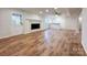 Open living room with wood flooring, a fireplace, and a glass door leading to the exterior of the home at 12011 Stoney Meadow Dr, Mint Hill, NC 28227
