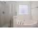 Bathroom featuring a large tub, glass-door shower, tile flooring, and a window for natural light at 125 Colville Rd, Mooresville, NC 28117