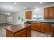 Well-lit kitchen features an island, wood cabinets, stainless steel appliances, and access to the backyard at 125 Colville Rd, Mooresville, NC 28117