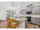 Well-lit eat-in kitchen boasts gray cabinets, stainless steel appliances, granite countertops, and barstool seating at 12706 Heath Grove Dr, Huntersville, NC 28078