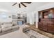 Open-concept living room with gray sectional, ceiling fan, and an eat-in kitchen area with stainless steel appliances at 12706 Heath Grove Dr, Huntersville, NC 28078