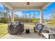 Covered porch with grill, ceiling fan, wicker furniture, and views of the backyard at 12706 Heath Grove Dr, Huntersville, NC 28078