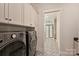 Spacious laundry room area with washer and dryer and bright tiled floors at 12912 Bailey Rd, Cornelius, NC 28031