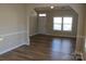 Cozy living room with wood flooring, brightened by natural light from the front windows at 13016 Meadowmere Rd, Huntersville, NC 28078