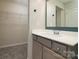 Well-lit bathroom with modern fixtures, white vanity, and walk in closet at 13304 Porter Creek Rd, Charlotte, NC 28262