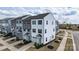 A row of townhouses featuring varied neutral tones, complemented by well-maintained landscaping and private garages at 13304 Porter Creek Rd, Charlotte, NC 28262