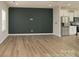 An empty living room with dark accent wall and an open floorplan to the kitchen with stainless steel appliances at 13304 Porter Creek Rd, Charlotte, NC 28262