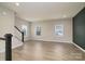 Bright living room with wood floors, large windows, and a view of the staircase at 13304 Porter Creek Rd, Charlotte, NC 28262