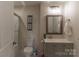 Bathroom with gray cabinets, shower, toilet and mirror at 1358 37Th Avenue Ne Pl, Hickory, NC 28601