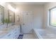 Well-lit bathroom with double sink vanity, elegant mirrors, and a soaking tub with a bright, airy ambiance at 1358 37Th Avenue Ne Pl, Hickory, NC 28601